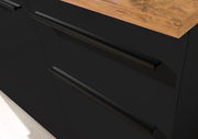 Nahaufnahme einer schwarzen Küchenschublade mit Holzarbeitsplatte, seitliche Perspektive