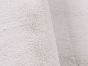 Nahaufnahme eines weißen Fellteppichs mit weicher Textur, seitliche Perspektive