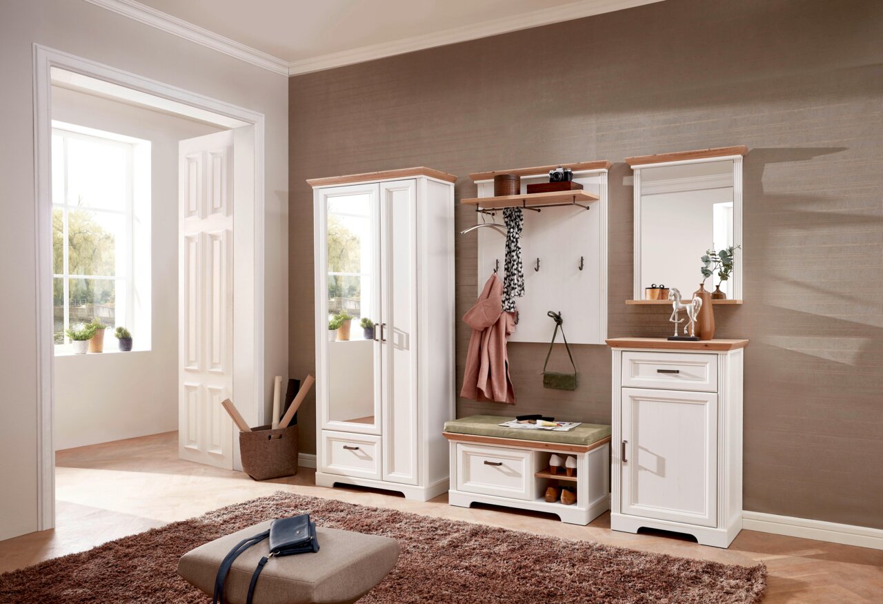 Garderoben-Set in einem modernen Flur mit schmalem Garderobenschrank, Spiegel, Schuhschrank und Garderobenpaneel in weißer Holzoptik, seitliche Perspektive.