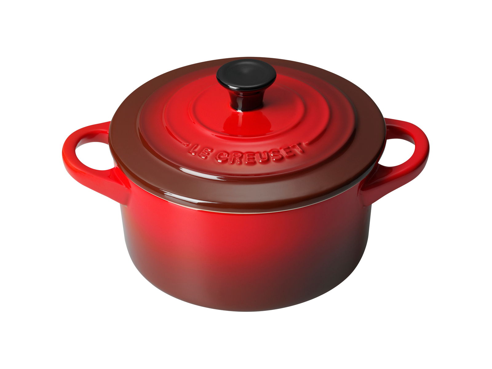 LE CREUSET Mini Cocotte 10cm Kirschrot Rote Le Creuset Mini-Cocotte aus der Vogelperspektive mit zwei Griffen und schwarzem Knauf auf dem Deckel.