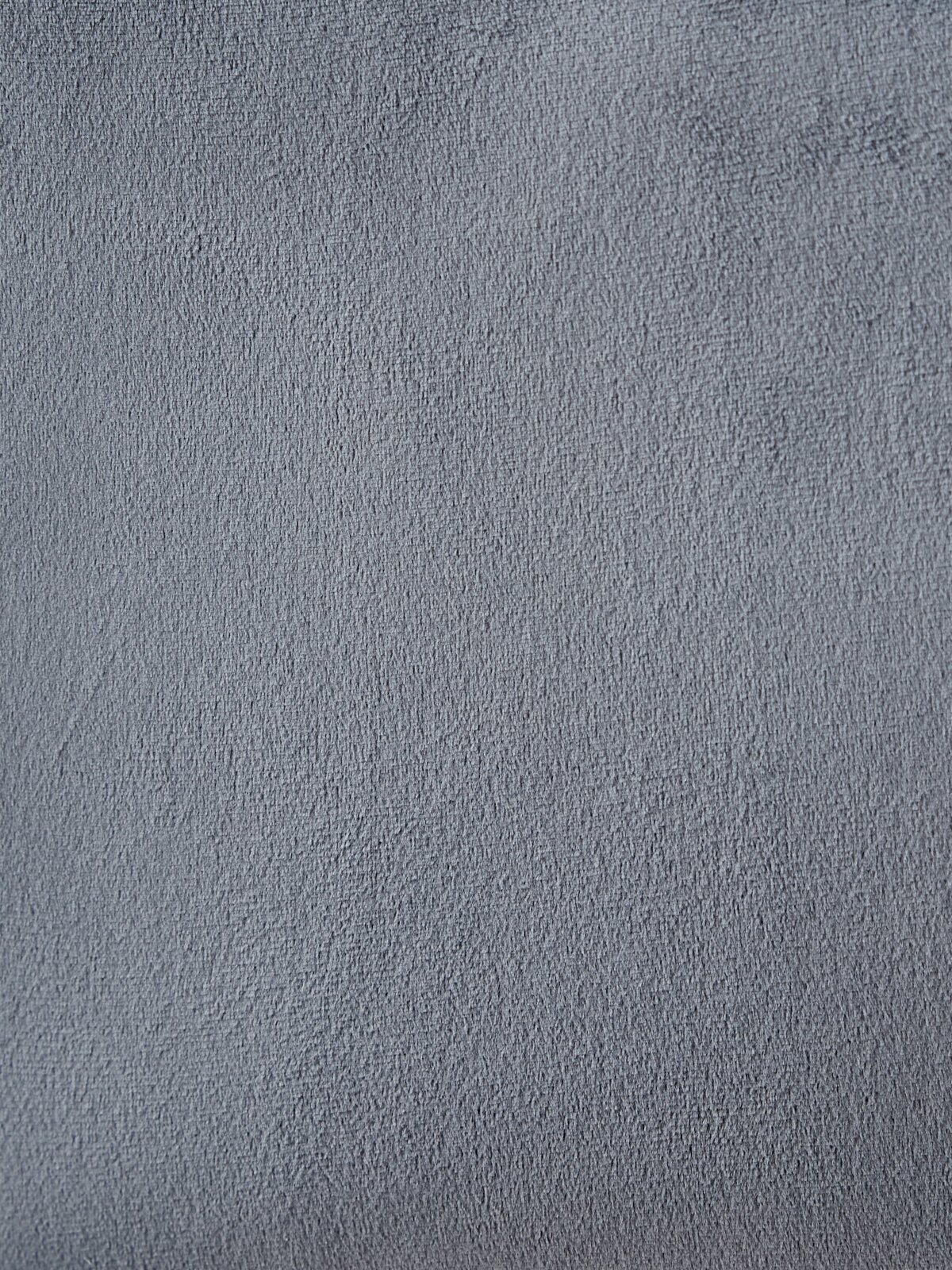 Close-up van een grijze stofstructuur, mogelijk de bekleding van een fauteuil