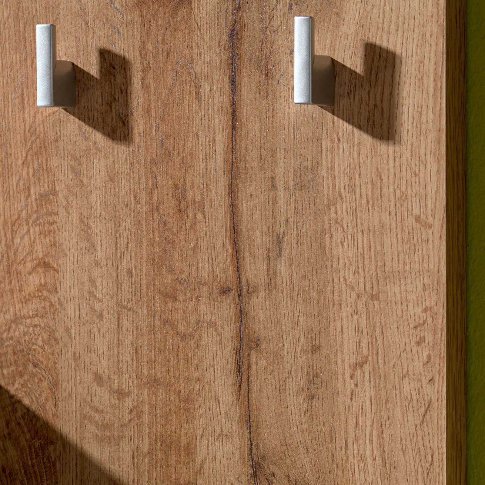 Nahaufnahme einer Kompakt-Garderobe aus Holz mit zwei silbernen Haken, seitliche Perspektive.