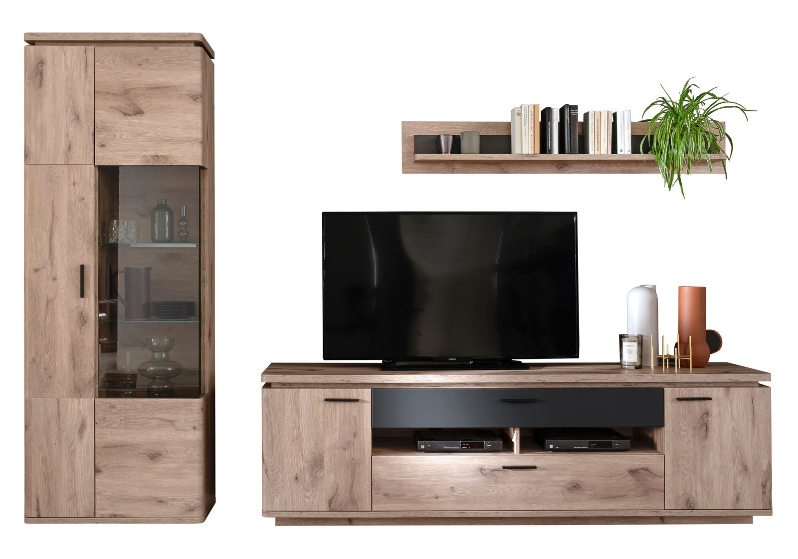 Zurbrüggen Wandkombination MODENA Frontale Ansicht der Zurbrüggen Wandkombination MODENA mit einem hohen Schrank, einem TV-Board mit Fernseher und einem Wandregal, dekoriert mit Büchern und Pflanzen.