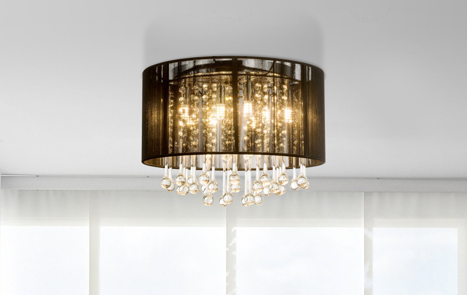 Moderne LED-Deckenleuchte mit schwarzem Schirm und hängenden Kristallen, seitliche Perspektive