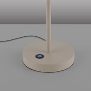 Nahaufnahme des runden Standfußes einer weißen Tischlampe mit blau beleuchtetem Touch-Ein-/Aus-Schalter und schwarzem Kabel, fotografiert frontal aus leicht erhöhter Perspektive
