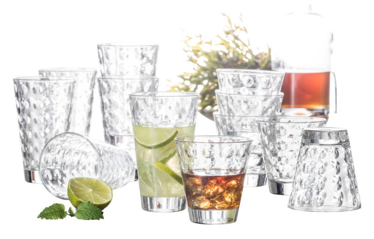 Leonardo Becherset 12-tlg. OPTIC Ein 12-teiliges Becherset mit optischem Design, bestehend aus klaren Gläsern mit strukturierter Oberfläche. Die Gläser sind in verschiedenen Perspektiven angeordnet, einige gefüllt mit Getränken und dekoriert mit Limetten und Minze.