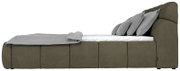 Zijaanzicht van een modern gestoffeerd bed in olijfgroen met grijze kussens en een deken.