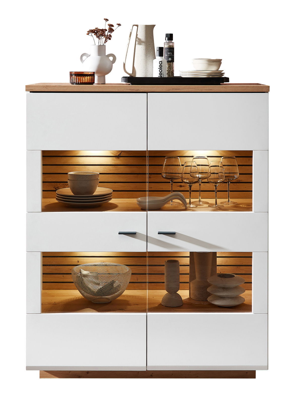 Zurbrüggen Highboard FRESNO Frontansicht des Highboards Zurbrüggen FRESNO mit weißem Korpus, Holzdetails und integrierter Beleuchtung, dekoriert mit Geschirr und Gläsern.