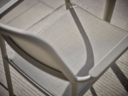 Nahaufnahme eines Stapelsessels aus Metall mit Textilbespannung, von oben betrachtet.