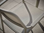 Nahaufnahme eines Stapelsessels aus Metall mit Textilbespannung, von oben betrachtet.