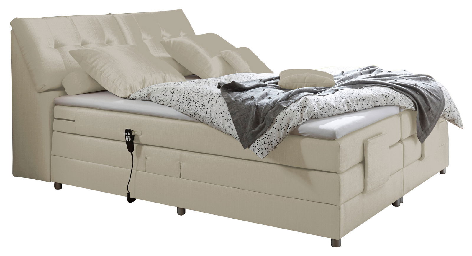 Beiges Boxspringbett mit gepolstertem Kopfteil, dekorativen Kissen und gemustertem Bettbezug, seitliche Perspektive