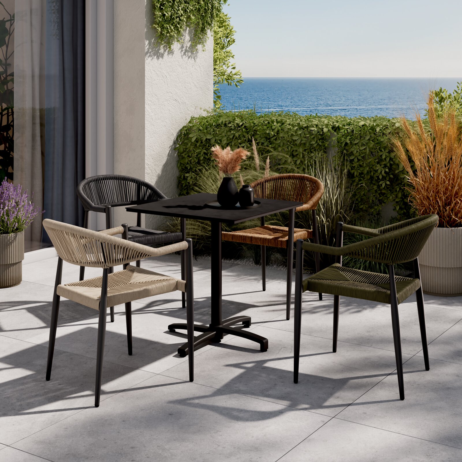 Ambia Garden Bistrotisch FLIP Moderner Bistrotisch auf einer Terrasse mit Meerblick, umgeben von vier stilvollen Stühlen in verschiedenen Farben, aus der Perspektive von schräg oben fotografiert.