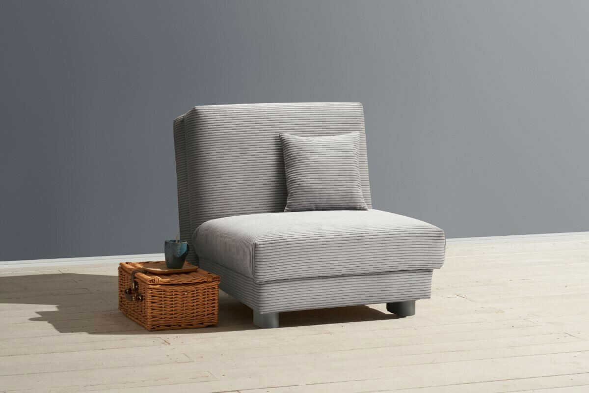 Grauer Funktionssessel mit Kissen, seitliche Perspektive, auf hellem Holzboden neben einem Korb mit Tasse.