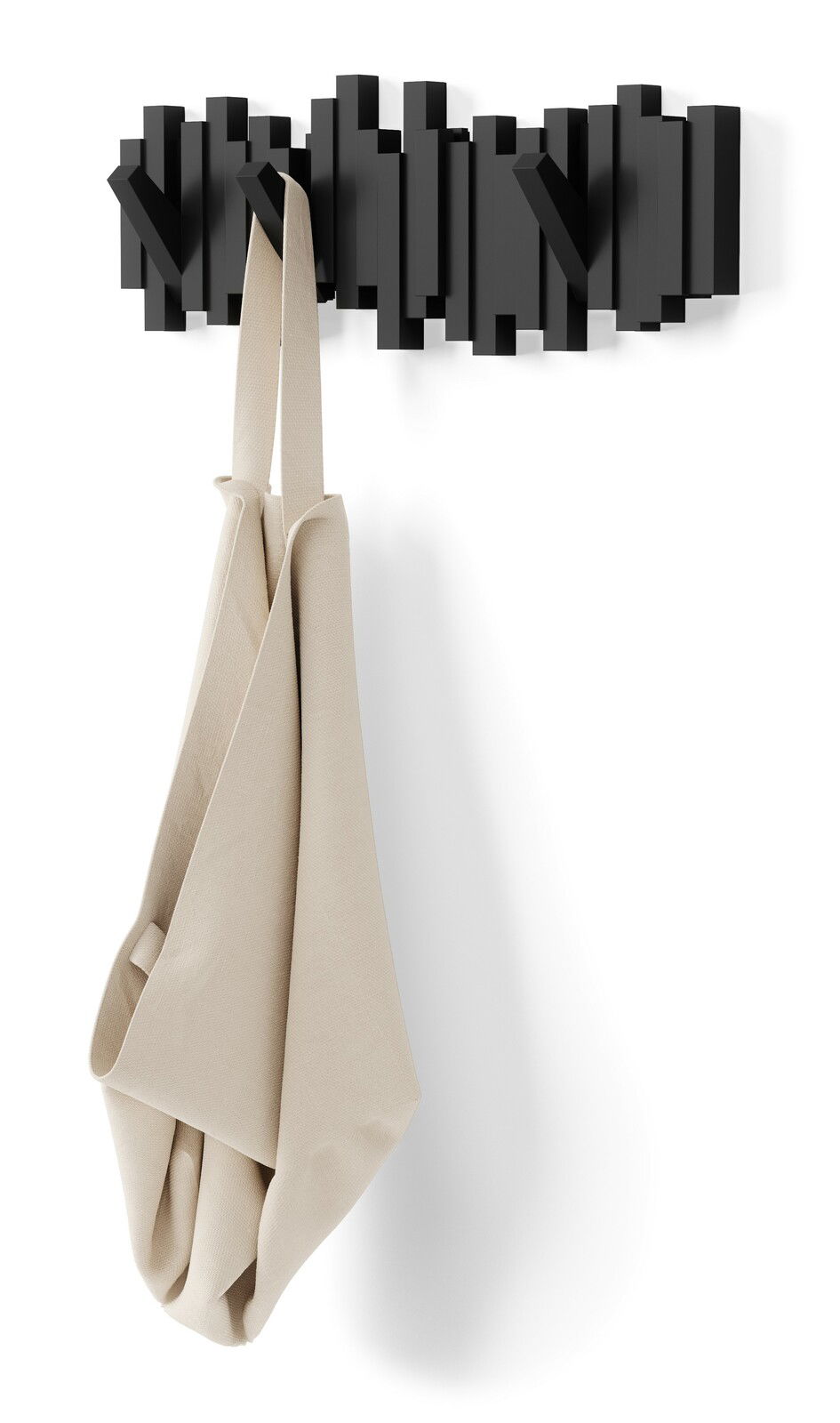 Moderne Wandgarderobe in Schwarz mit geometrischem Design, frontal abgebildet, mit einem beigen Stoffbeutel daran hängend.