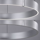 Moderne, runde Pendelleuchte aus gebürstetem Metall mit seitlicher Perspektive, die das minimalistische Design und die gleichmäßige Lichtverteilung zeigt.