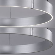 Moderne, runde Pendelleuchte aus gebürstetem Metall mit seitlicher Perspektive, die das minimalistische Design und die gleichmäßige Lichtverteilung zeigt.