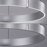 Moderne, runde Pendelleuchte aus gebürstetem Metall mit seitlicher Perspektive, die das minimalistische Design und die gleichmäßige Lichtverteilung zeigt.