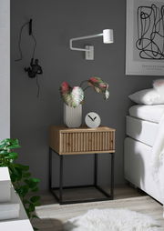 Moderne Nachtkommode aus Holz mit schwarzem Metallgestell, dekoriert mit einer Pflanze und einer Uhr, seitliche Perspektive.