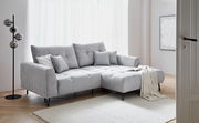 Graues Ecksofa SWING mit Ottomane, dekoriert mit Kissen und Decke, in einem hellen Wohnzimmer, seitliche Perspektive.