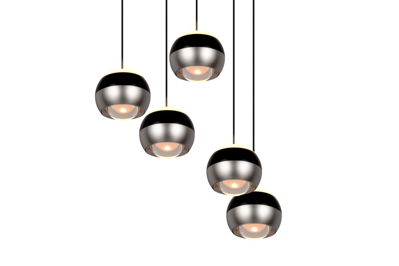 Vijf moderne, bolvormige hanglampen in zwart en zilver, gezien van onderaf, met warm licht.