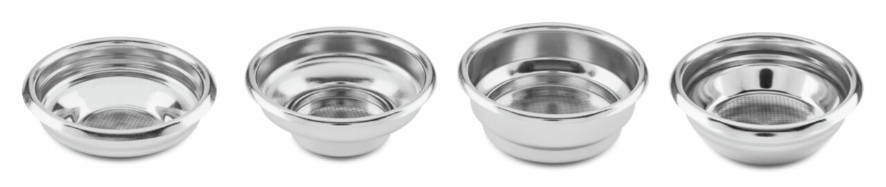 Vier Edelstahl-Siebeinsätze für Espressomaschinen, frontal nebeneinander angeordnet.