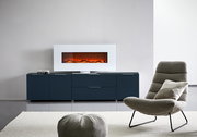 Frontale Ansicht eines modernen XL-TV-Lowboards in dunklem Blau mit integriertem Elektrokamin, platziert in einem stilvollen Wohnzimmer.