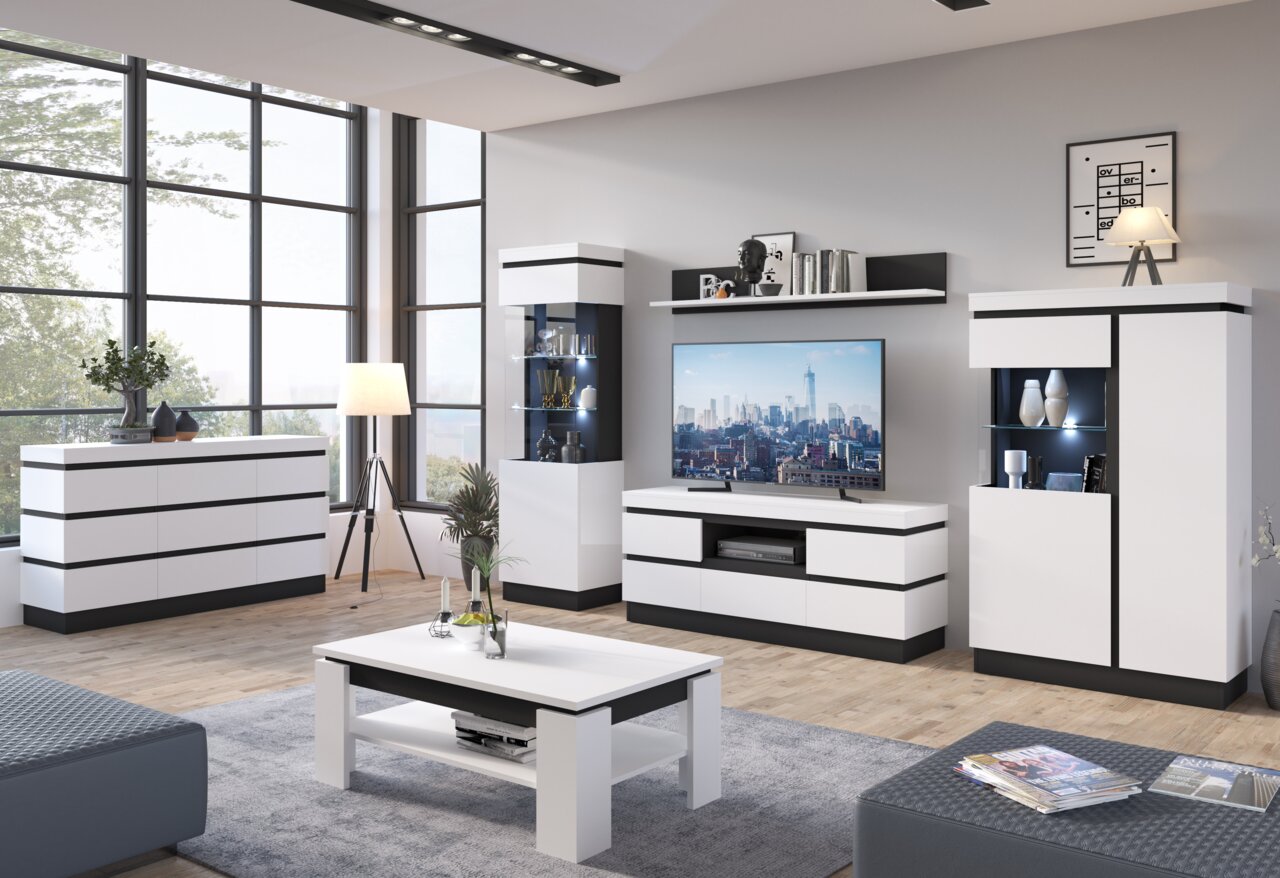 Moderne Wohnzimmermöbel in einem hellen Raum mit großen Fenstern, bestehend aus einem weißen Sideboard, einem Couchtisch, einem TV-Lowboard und einer Vitrine. Perspektive: Frontalansicht.