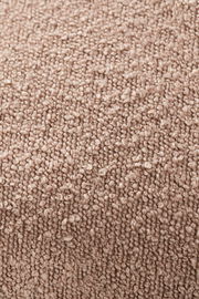 Nahaufnahme einer strukturierten, beigen Stoffoberfläche, vermutlich von einer Zierkissenhülle.