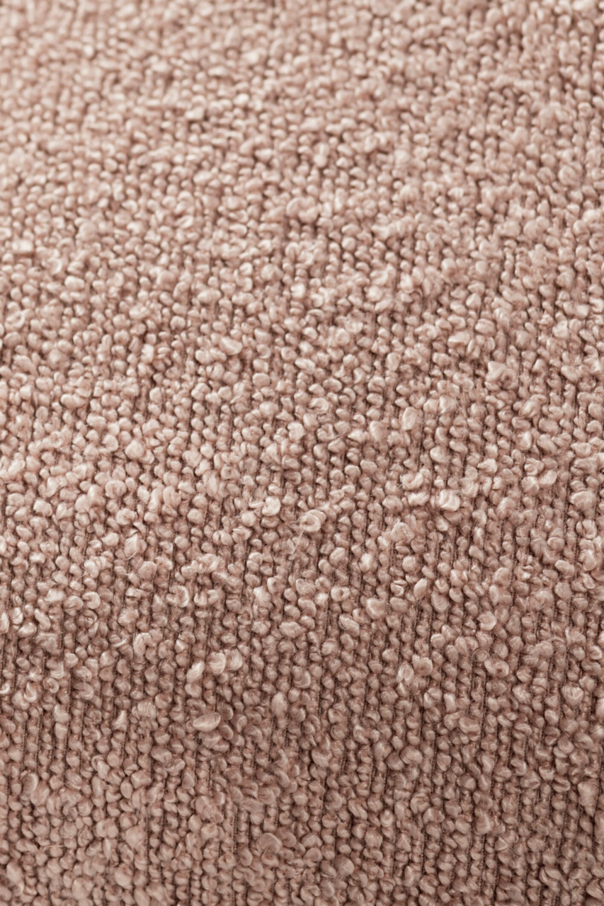 Nahaufnahme einer strukturierten, beigen Stoffoberfläche, vermutlich von einer Zierkissenhülle.