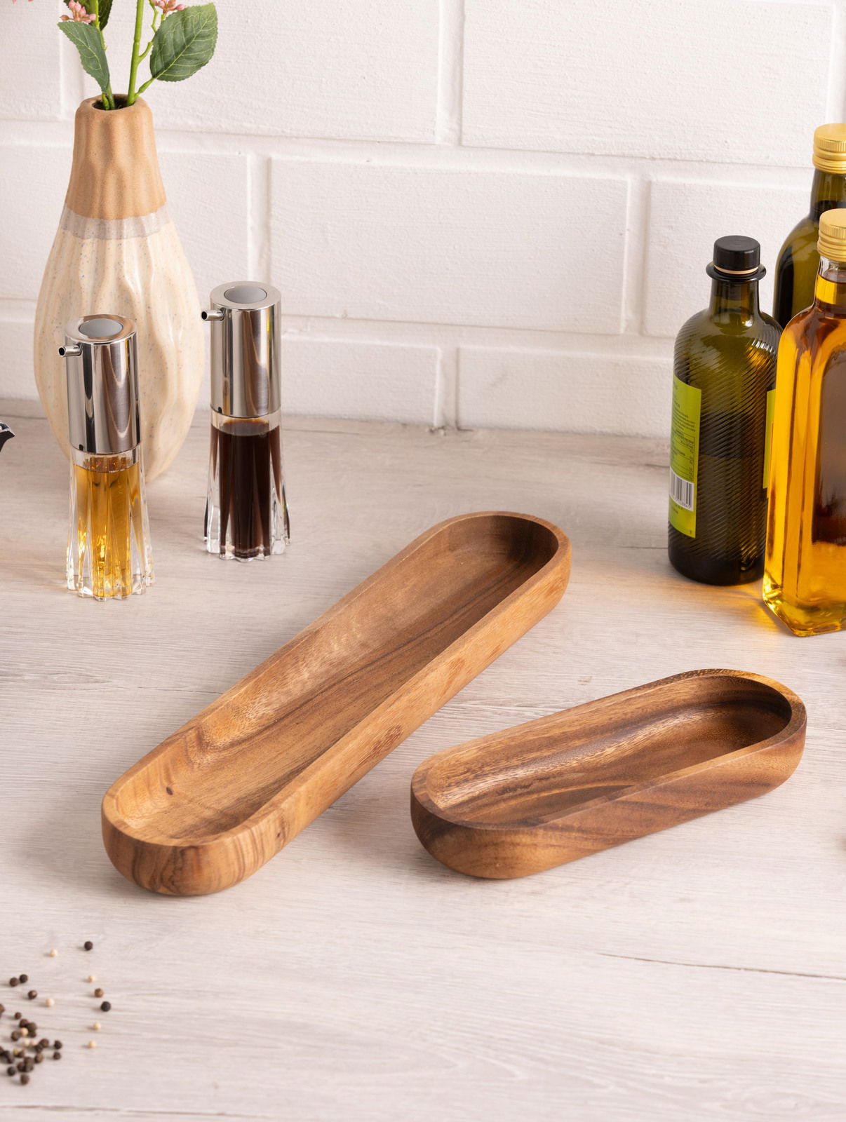 Holz-Baguette-Schale in rechteckiger Form, auf einem Tisch arrangiert, umgeben von Gewürzflaschen und einer Vase, aus der Vogelperspektive fotografiert.