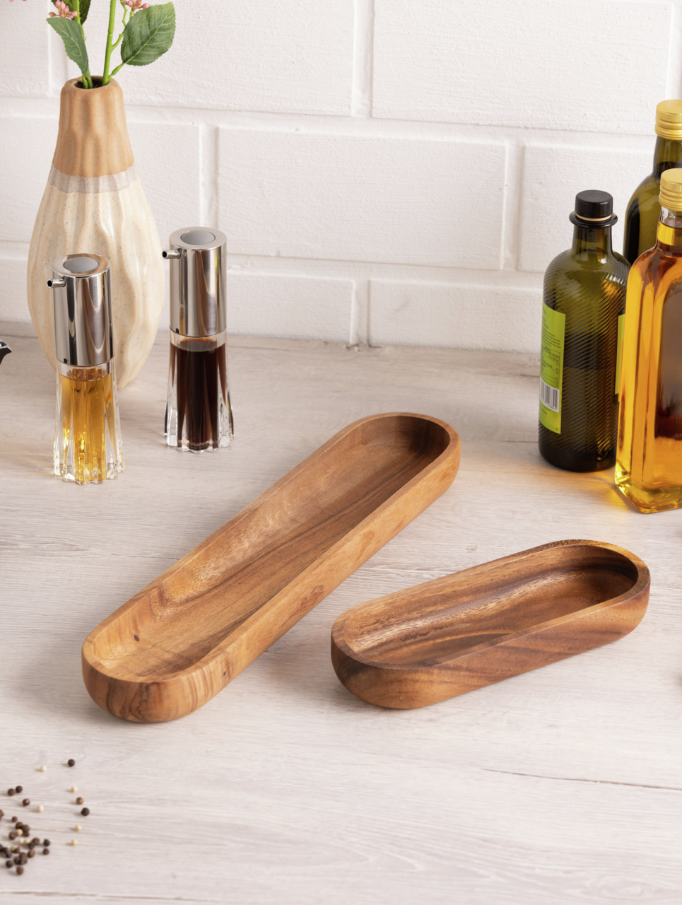 Holz-Baguette-Schale in rechteckiger Form, auf einem Tisch arrangiert, umgeben von Gewürzflaschen und einer Vase, aus der Vogelperspektive fotografiert.