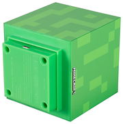 Grüner, würfelförmiger Minecraft-Block mit Pixelmuster und seitlichem „MINECRAFT“-Logo, Rückansicht in schräger Perspektive mit sichtbarer Unterseite und Micro-USB-Anschluss.