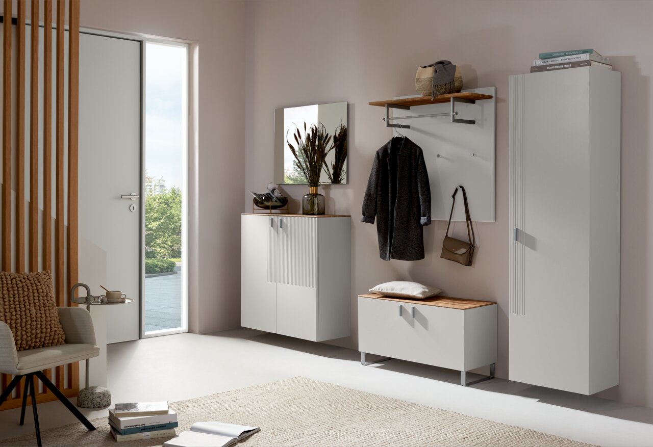 Moderne Garderobeneinrichtung mit Schuhschrank, Garderobenpaneel und Spiegel in heller, einladender Atmosphäre, seitliche Perspektive.