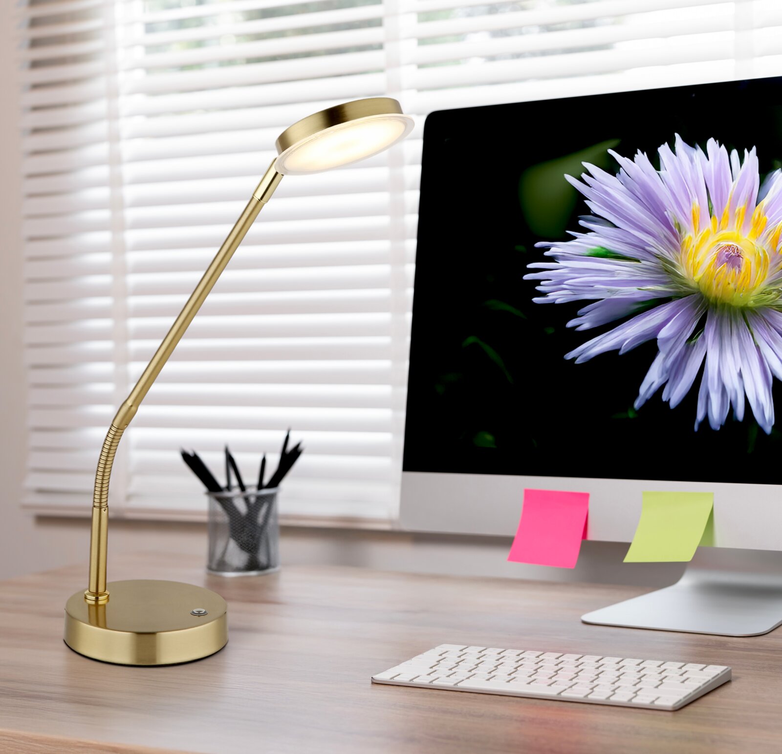 Globo Lighting LED-tafellamp SILVIO Elegante gouden led-tafellamp op een bureau, gezien vanaf de zijkant, naast een computerscherm met een bloem.