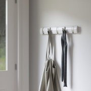 Wandgarderobe mit mehreren Haken, an denen Taschen und ein Schal hängen, seitliche Perspektive
