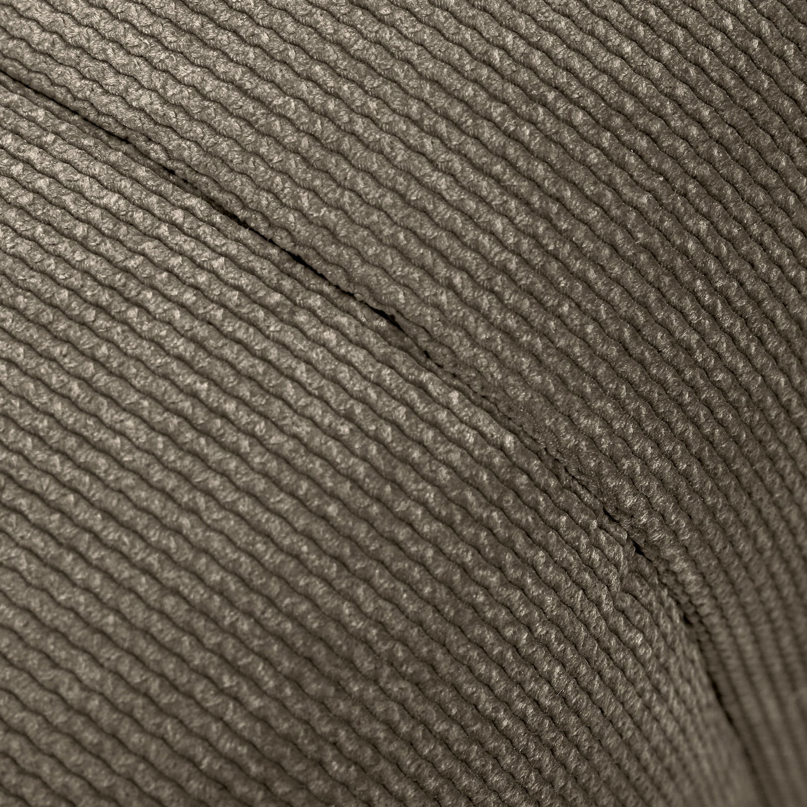 Nahaufnahme der strukturierten Oberfläche eines Hockers aus gewebtem Material, seitliche Perspektive