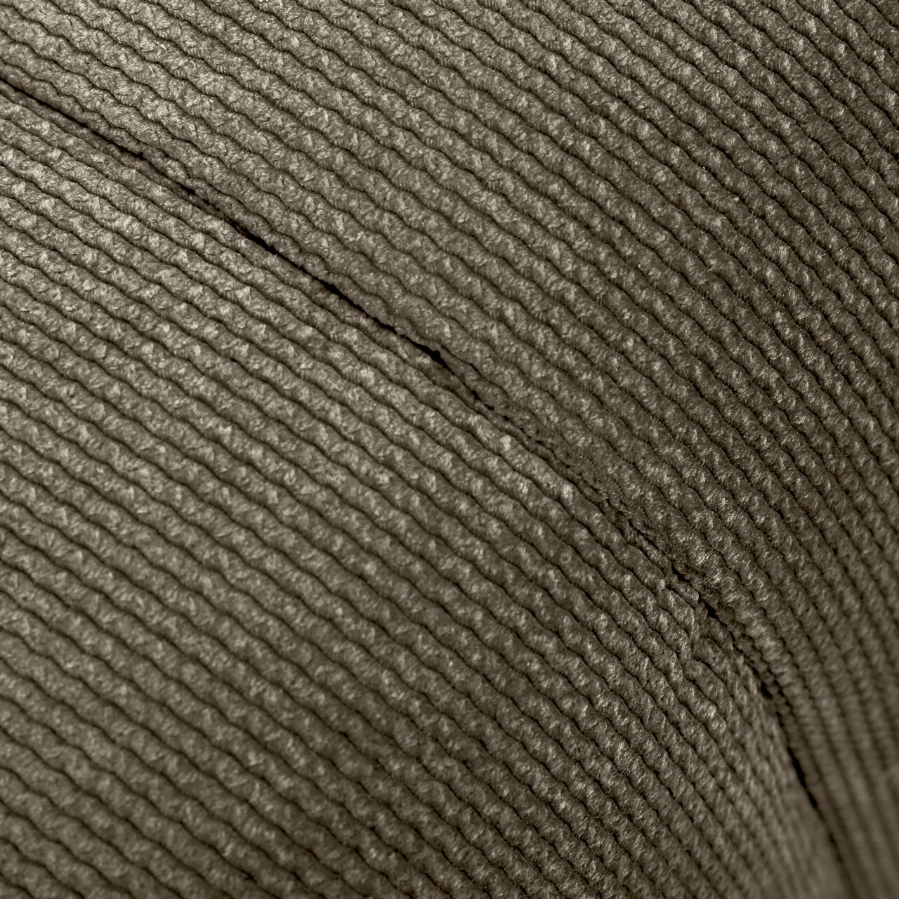 Nahaufnahme der strukturierten Oberfläche eines Hockers aus gewebtem Material, seitliche Perspektive