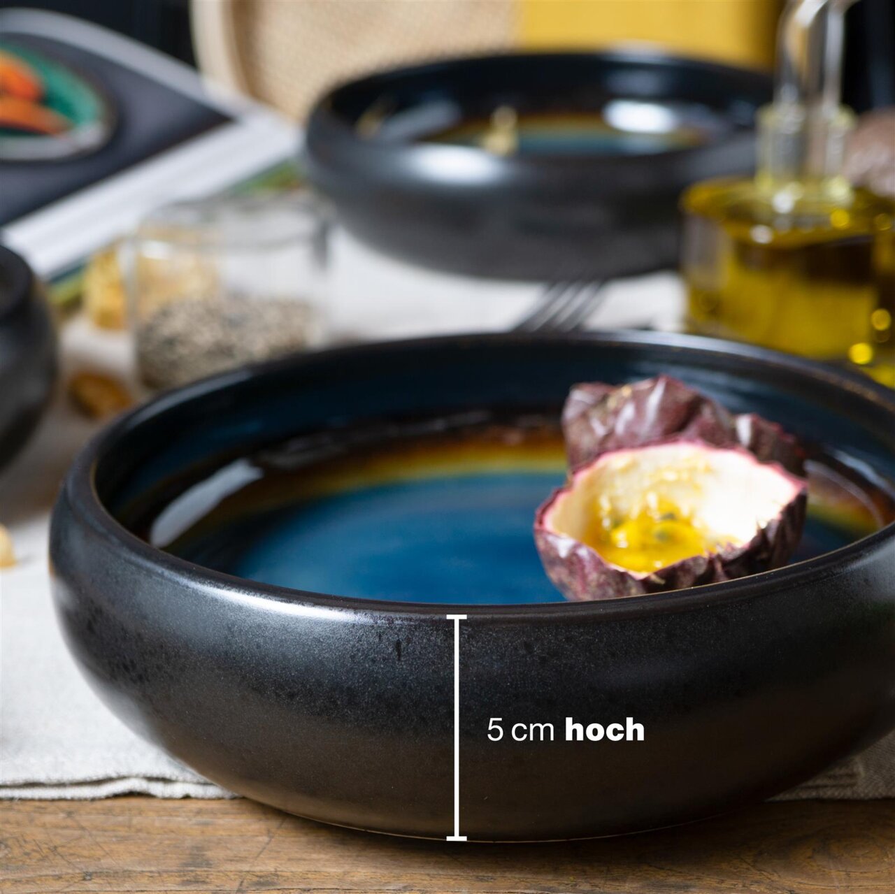 Seitliche Ansicht eines blauen und braunen Suppentellers mit 5 cm Höhe, dekoriert mit einer halben Passionsfrucht.