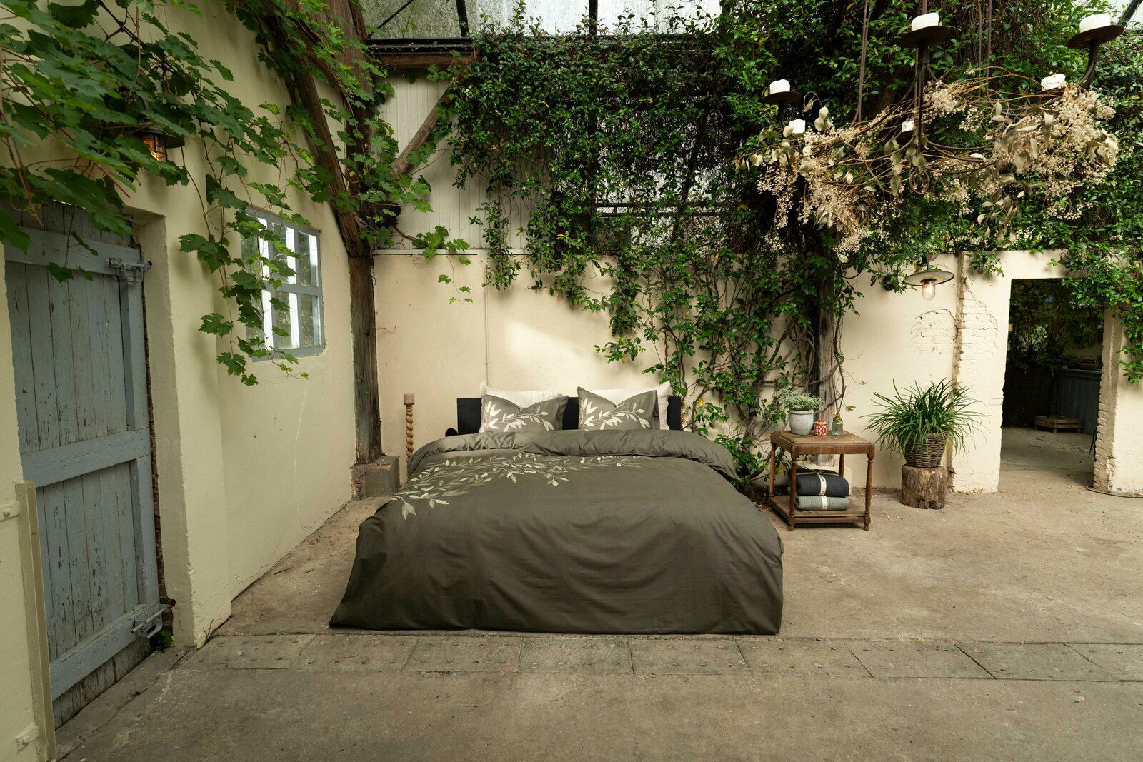 Bettwäsche 135x200cm in einem rustikalen, von Pflanzen umgebenen Raum, aus der Vorderansicht fotografiert.