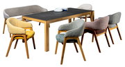 Esszimmer mit einem modernen Tisch und sechs farbenfrohen Armlehnstühlen aus Holz, aus der Perspektive von vorne.