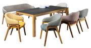 Esszimmer mit einem modernen Tisch und sechs farbenfrohen Armlehnstühlen aus Holz, aus der Perspektive von vorne.
