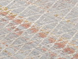 Nahaufnahme eines Designer Teppichs mit geometrischem Muster in Grau, Rot und Gelb. Die Perspektive zeigt eine schräge Ansicht der Teppichoberfläche.