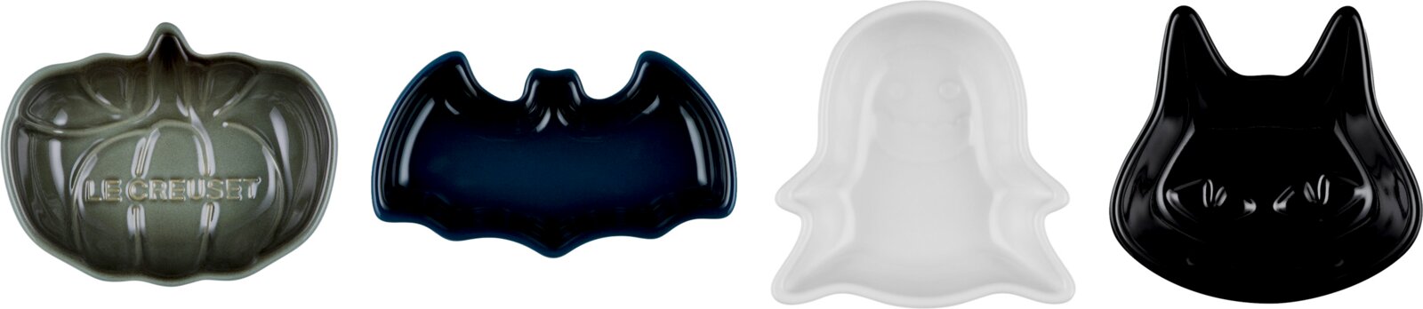 Vier glänzende Le Creuset Keramikschälchen in Kürbis-, Fledermaus-, Geister- und Katzenform, aus der Draufsicht vor weißem Hintergrund