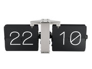 Vooraanzicht van een KARLSSON-wandklok in flip-clock-stijl zonder behuizing, met zwarte klepjes en witte cijfers.