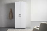 Weißer XL-Schuhschrank mit zwei Türen, frontal fotografiert, neben einer grauen Wand mit hängendem Mantel.
