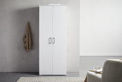 Weißer XL-Schuhschrank mit zwei Türen, frontal fotografiert, neben einer grauen Wand mit hängendem Mantel.