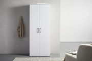 Weißer XL-Schuhschrank mit zwei Türen, frontal fotografiert, neben einer grauen Wand mit hängendem Mantel.