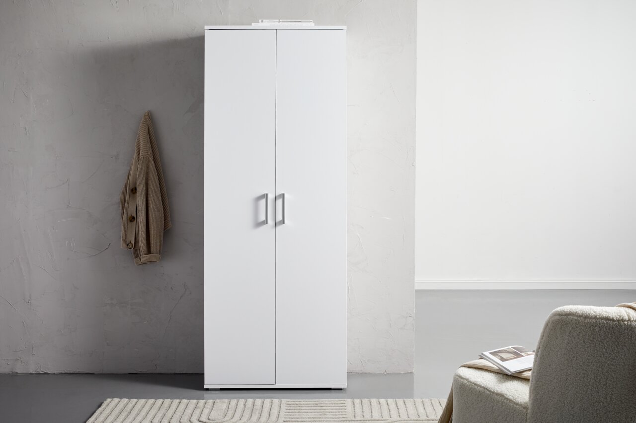XORA XL-schoenenkast ALEX Witte XL-schoenenkast met twee deuren, gefotografeerd vanaf de voorkant, naast een grijze muur met een opgehangen jas.