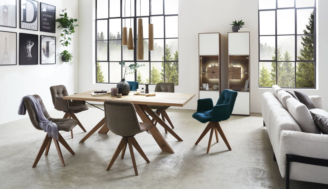 Moderne Vitrine Valnatura LAGO in einem stilvollen Wohnzimmer, links im Bild, mit großen Fenstern im Hintergrund.