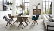 De moderne vitrinekast Valnatura LAGO in een stijlvolle woonkamer, links op de foto, met grote ramen op de achtergrond.